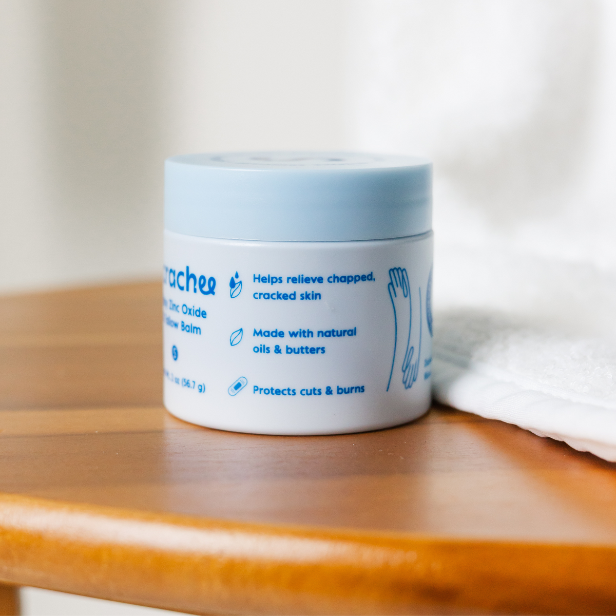 Jar of Scrachee zinc oxide balm on a wooden surface with a white background