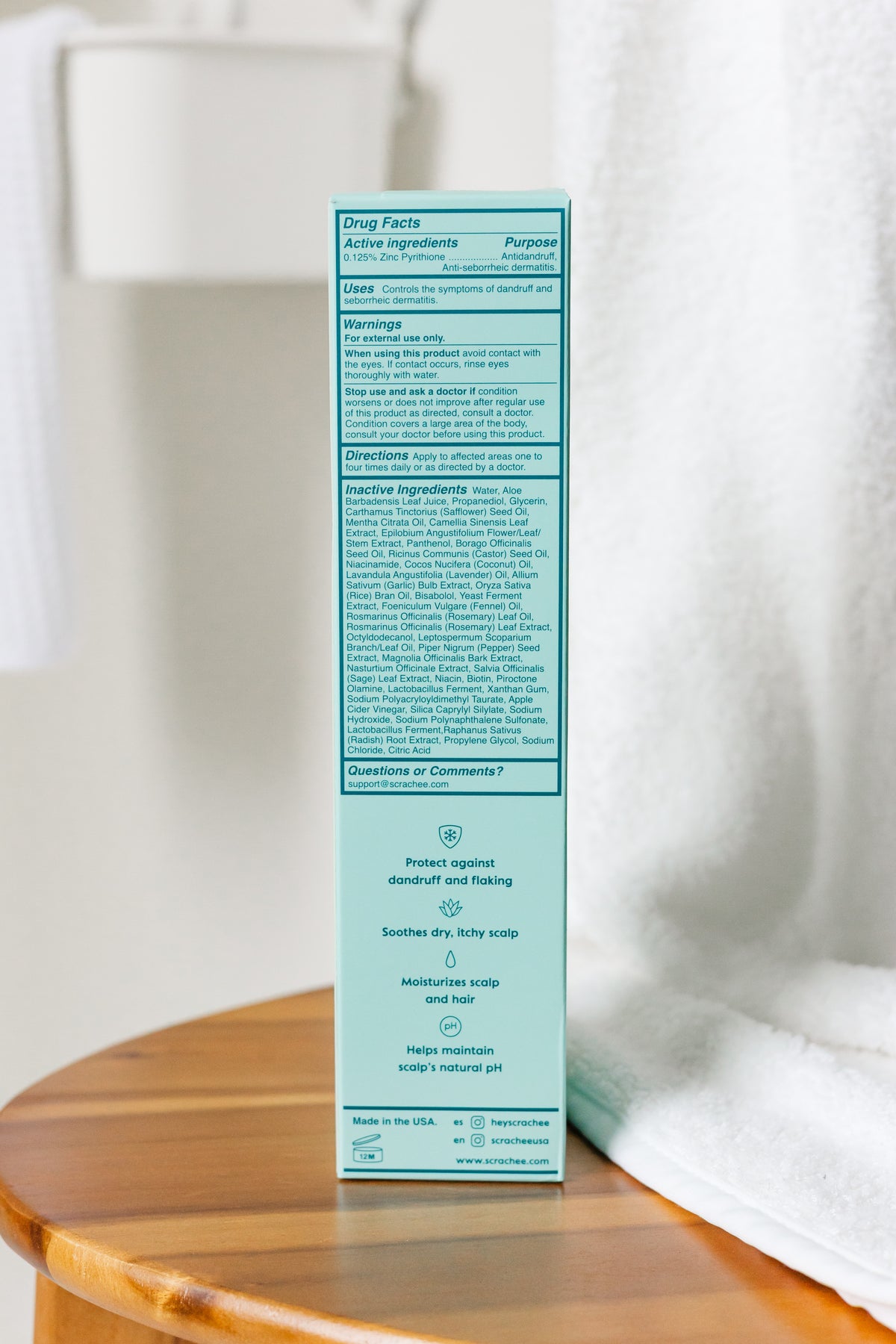 Product packaging with text on a wooden surface and white towel background