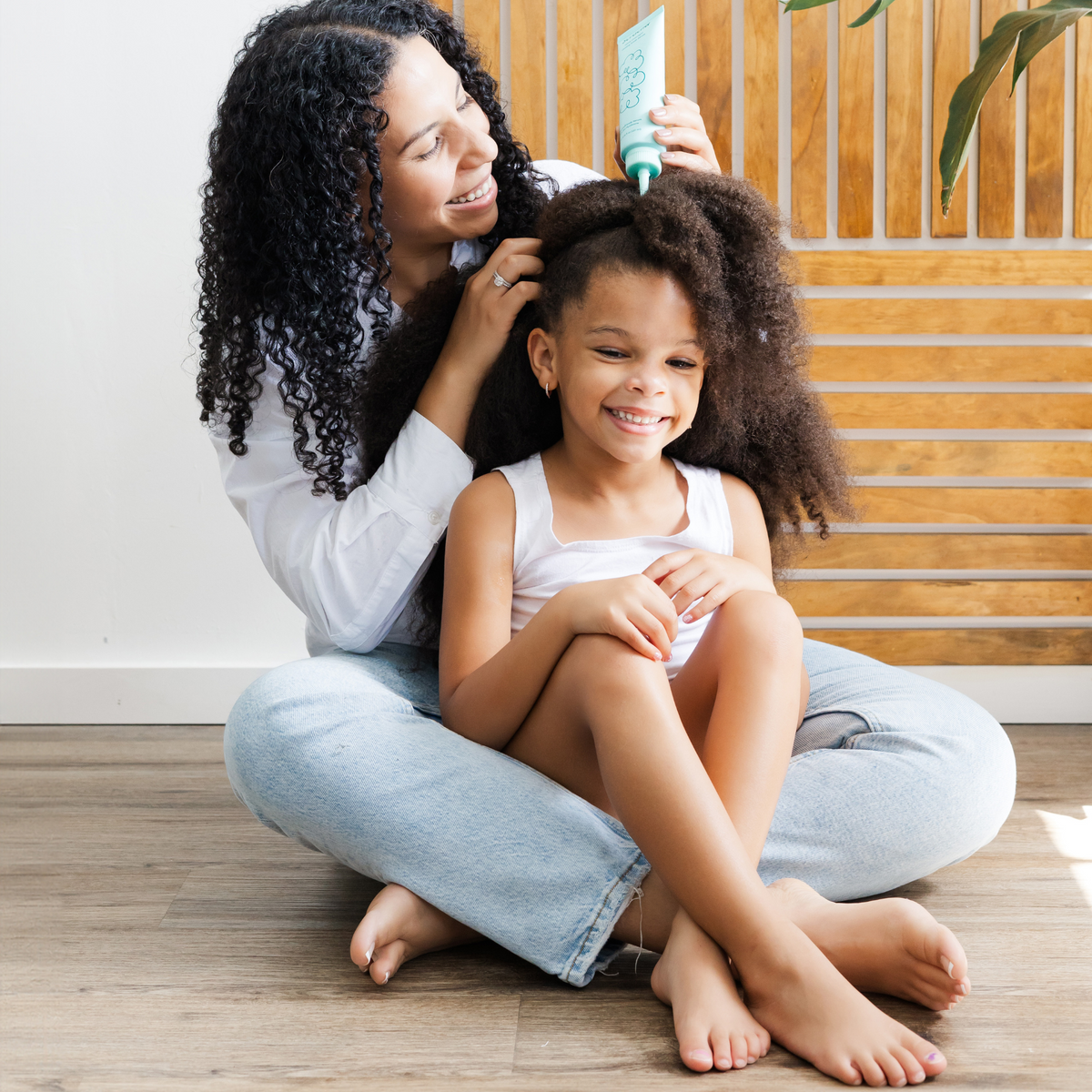 A mom applying Scrachee's  Scalp Serum on her daughter's scalp.