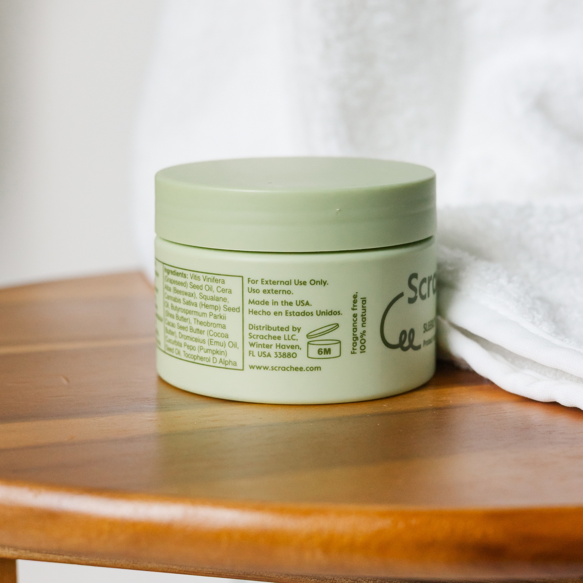 Green jar with a white label on a wooden surface