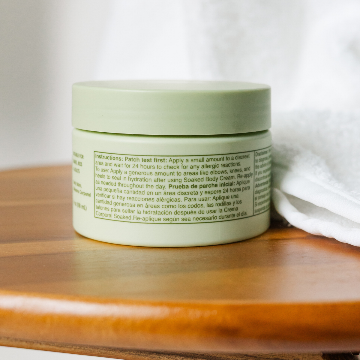 Green jar with text on a wooden surface