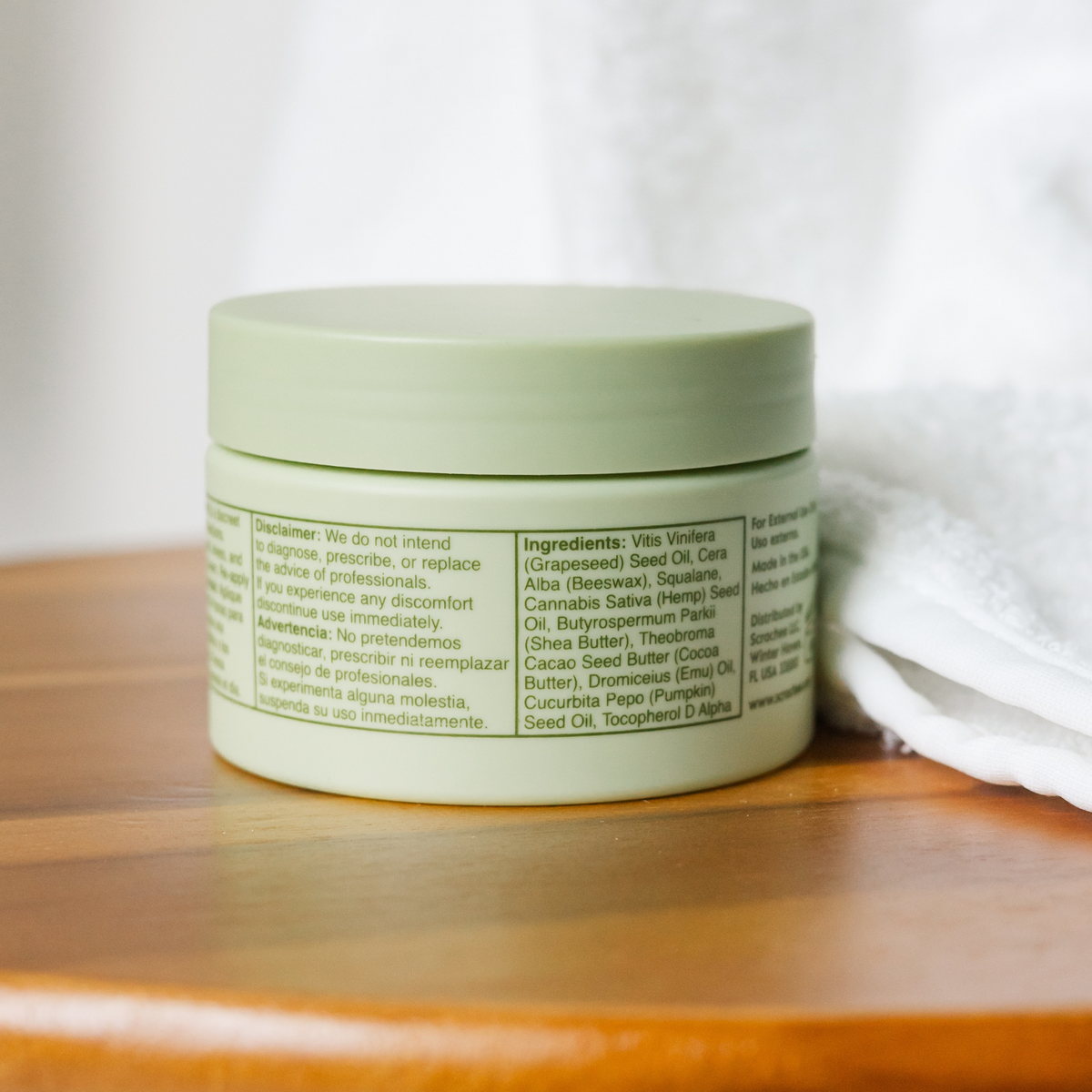 Green jar with a label on a wooden surface