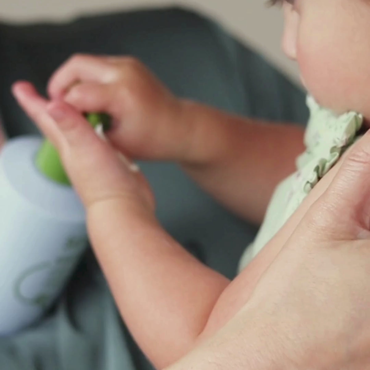 A baby applying Scrachee's Soaked OG cream on her hands.